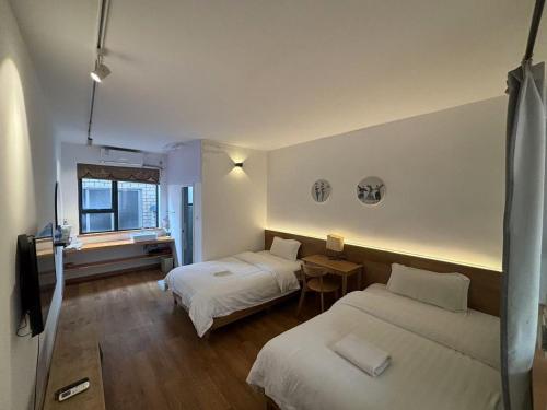 a hotel room with two beds and a window at Junshe Youth Hostel in Guilin