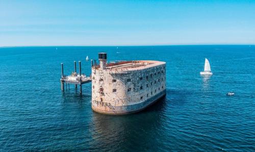 a boat in the water with a sailboat in the ocean at Mobil Home Moderne de 40m2 TOUT CONFORT Camping SIBLU Les CHARMETTES 785 La Palmyre Les Mathes in Les Mathes
