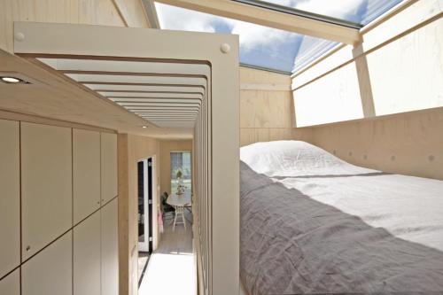 a bedroom with a bed and a window at Zondag aan Zee - Ecohuisjes Terschelling in Midsland