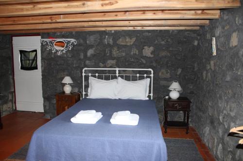 a bedroom with a bed with two towels on it at Aldeia das Cagarras in Santo Amaro
