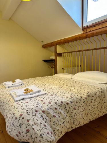 a bedroom with a bed with two towels on it at Agriturismo Ca du Chittu in Carro