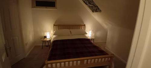 a small bedroom with a bed with two night stands at Harnham Flat in Salisbury