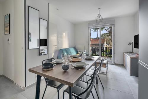 une salle à manger avec une table et des chaises en bois dans l'établissement Appartement pour 4 à 150m de la Mer, à Pornic