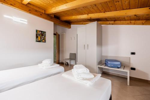 a room with two beds and a blue suitcase on a table at Appartamento La diMosa in Dro