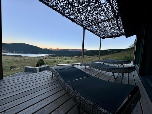 a deck with two lounge chairs and a bed on it at Artik chalet avec vue à 180 degrés et piscine in Les Angles