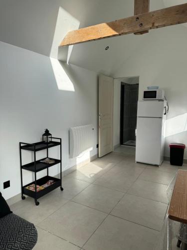 - une cuisine avec des murs blancs et un réfrigérateur blanc dans l'établissement A la ferme - Colline Beaumont, à Colline-Beaumont