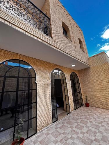 a large brick building with arched windows on it at Residence Tozeur Almadina in Tozeur