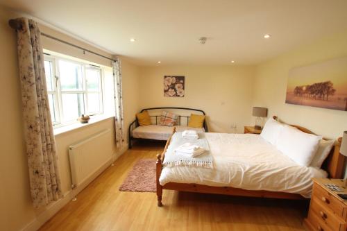 a bedroom with a bed and a window at The Eelsfoot inn in Theberton