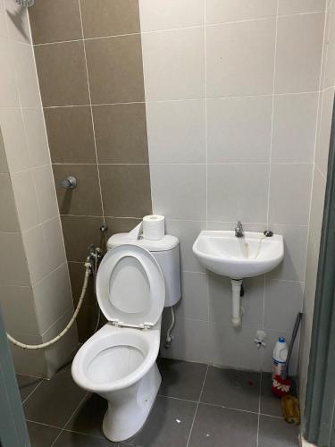 a bathroom with a toilet and a sink at Bright Apartment in Klebang in Ipoh