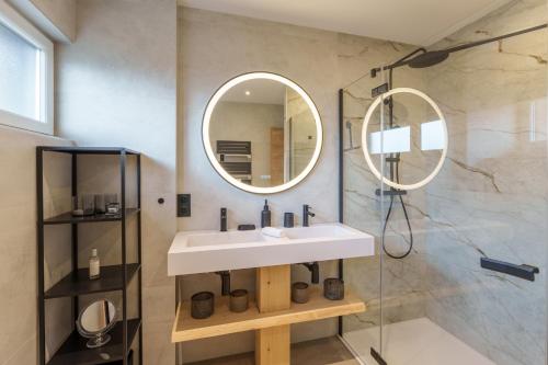 une salle de bain avec un lavabo et un miroir dans l'établissement L’Alma - Magnifique maison avec jacuzzi, à Gérardmer