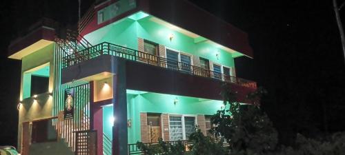 a large building with green lights on it at night at Budha Home Stay in Hampi