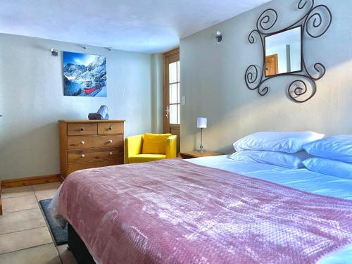 a bedroom with a large bed and a yellow chair at 4 Bedroom, 4 Bathroom, Hot Tub, Chamonix Centre in Chamonix-Mont-Blanc