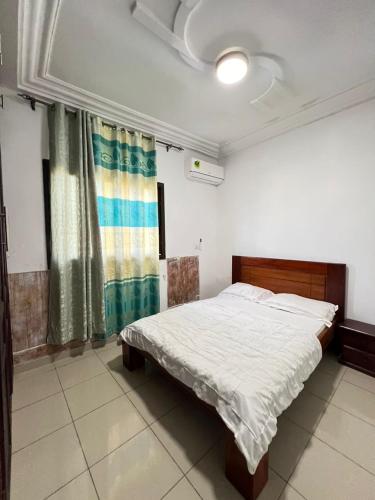 a bedroom with a bed and a window in it at Beau Séjour in Yaoundé