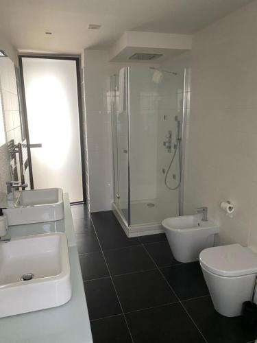 a bathroom with two sinks and a shower and a toilet at La Rosa nel Paese in Soveria Mannelli