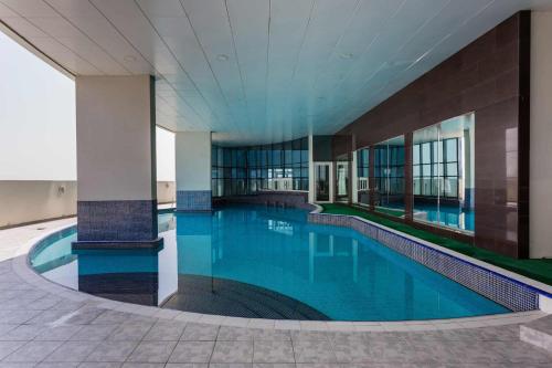 a large swimming pool in a building at Signature Studio JLT in Dubai