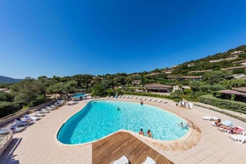 une grande piscine avec chaises et parasols dans l'établissement Mini villa Santa Giulia, à Porto-Vecchio
