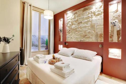 une chambre avec un lit avec des serviettes dessus dans l'établissement S Stylist and Unique Getaway 8p, à Paris