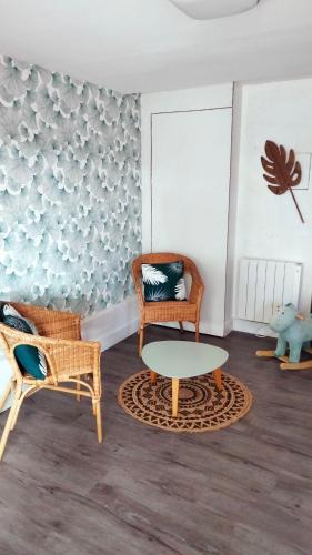 a living room with two chairs and a table at Gîte 100m2- piscine partagée in Meursac