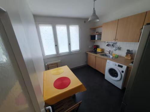 une petite cuisine avec une table et un lave-linge. dans l'établissement Le Drapeau : Apt 2 Personnes, 1 ch, avec Balcon, à Dijon