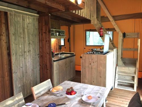 a kitchen with a table with a bowl of fruit on it at Trasimeno Glamping Resort in Magione