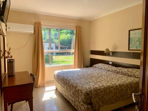 a bedroom with a bed and a window at HOTEL TROPICAL IGUAZU in Puerto Iguazú
