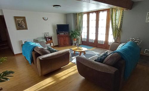 a living room with two couches and a tv at La Pitardière Gite in Villaines-la-Juhel