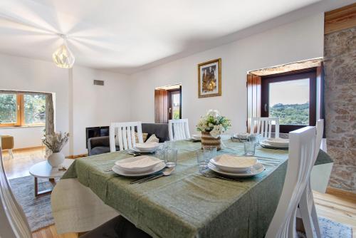 a dining room and living room with a table and chairs at Casa Do Pião - Turismo Rural in Ansião