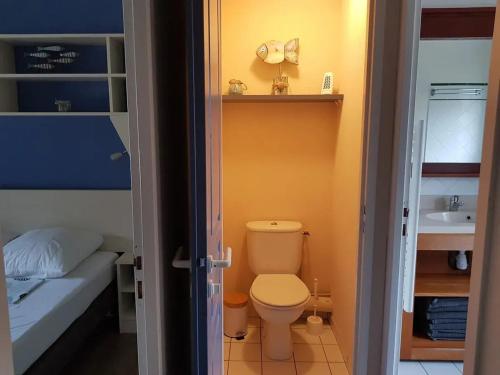 une petite salle de bain avec toilettes et lavabo dans l'établissement Maison charmante à Lacanau avec piscine partagée et terrasse, à Lacanau
