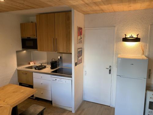 une cuisine avec un réfrigérateur blanc et une table dans l'établissement Seracs N 33 - 3P6, à Les Deux Alpes