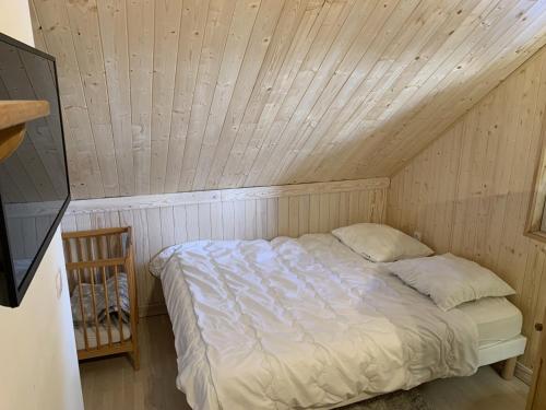 un lit dans une chambre avec un plafond en bois dans l'établissement Seracs N 33 - 3P6, à Les Deux Alpes