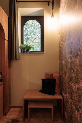 a bench in the corner of a room with a window at HoveniersHuis in Anzegem
