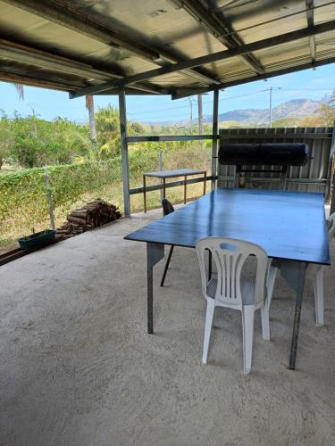 a blue table and two chairs on a patio at Maison de campagne la foa in Méaré