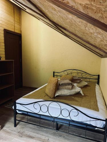 a bed with pillows on it in a room at Complex Brădișor in Malaia