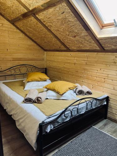 a large bed in a room with a wooden wall at Complex Brădișor in Malaia