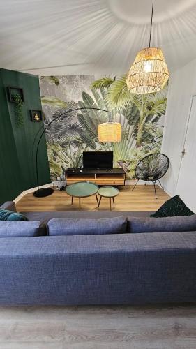 un salon avec un canapé bleu et une table dans l'établissement L'échappée sauvage-T3-Wifi- queen size, à Montluçon