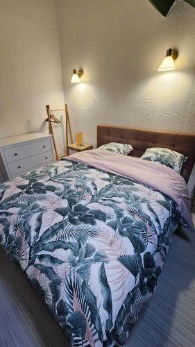 une chambre avec un lit avec une couverture bleue et blanche dans l'établissement L'échappée sauvage-T3-Wifi- queen size, à Montluçon