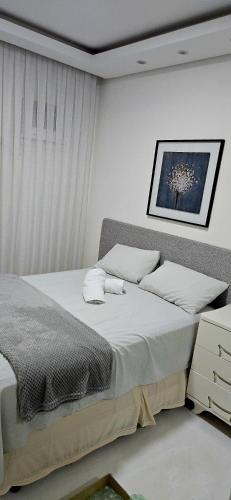 a bedroom with two beds and a picture on the wall at Flat Confortavel no Morumbi in São Paulo