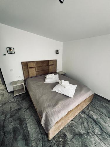 a bedroom with a bed with two pillows on it at Complex Brădișor in Malaia