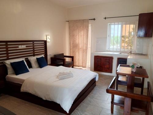 a bedroom with a large bed and a table at Atlantic view studio with Kitchen by Casa in Ebomé