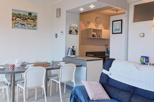 une cuisine et une salle à manger avec une table et des chaises dans l'établissement Ti Bihan - Perros Guirec, à Perros-Guirec