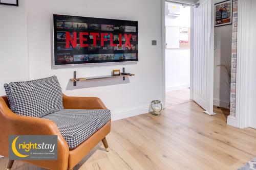 a living room with a chair and a tv on the wall at Birmingham Group Stay in Birmingham