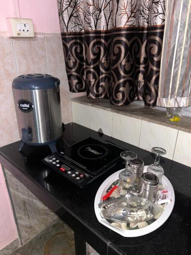 a coffee maker on a counter with a plate of dishes at Sujata Homestay in Queula