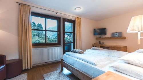 a bedroom with a bed and a large window at Felbermayer Hotel & AlpineSpa-Montafon in Gaschurn