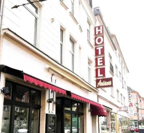 ケルンにあるHotel ARIANA Kölnの看板が掲げられた建物の店先