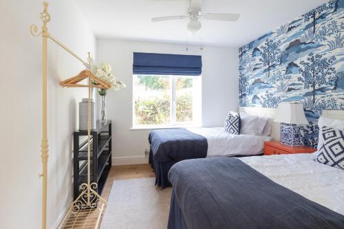 two beds in a room with blue and white wallpaper at Luxury Cornish Seaview Bungalow in Looe