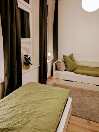 a bedroom with a bed and a couch and a window at Stylish city apartment in Siegen
