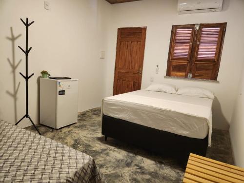 una camera con letto, frigorifero e finestra di Pousada Rio Leal a Luis Correia