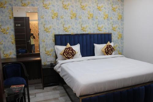 a bedroom with a bed with a blue and yellow wallpaper at Red Leaf Hotels in Chandīgarh