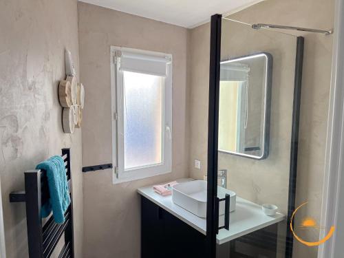 une salle de bain avec un lavabo et un miroir dans l'établissement Sur les quais, Sète Centre-ville, à Sète