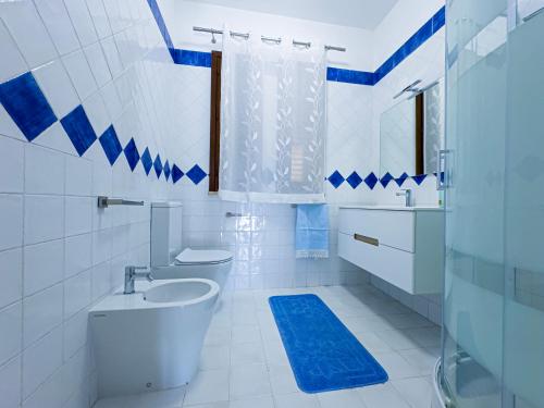 a blue and white bathroom with a toilet and a sink at Albachiara Apartment in Lampedusa